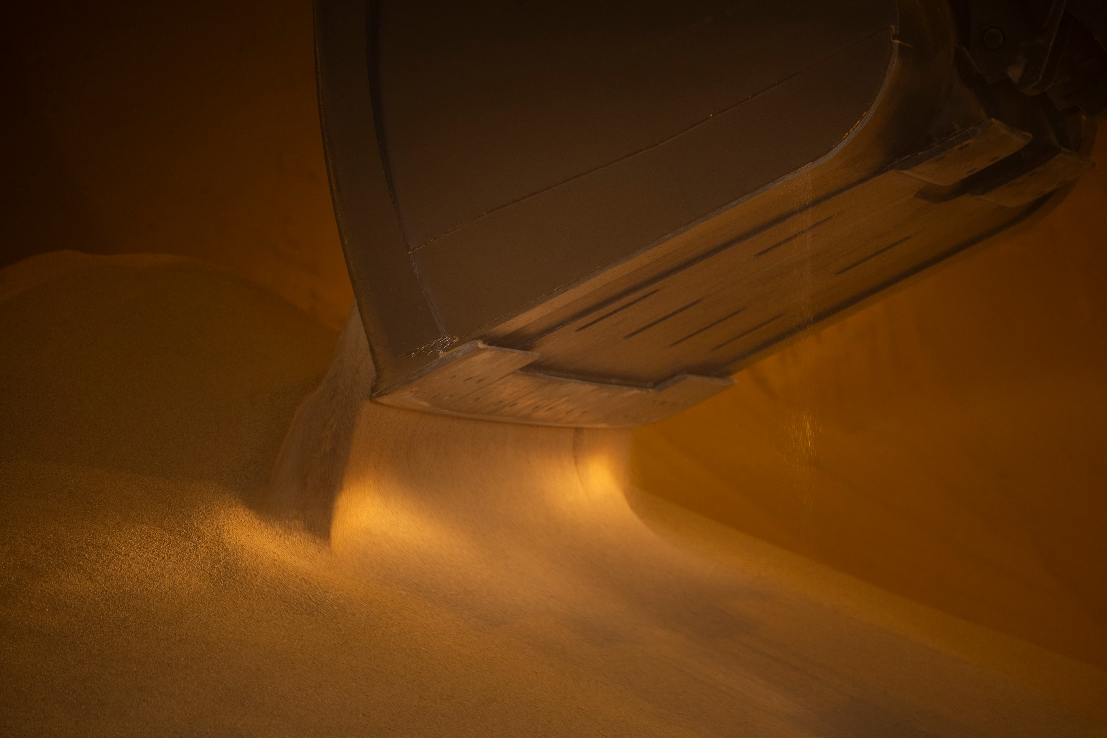 Grain being loaded and transported by truck at a bulk handling facility representing agricultural commodity logistics