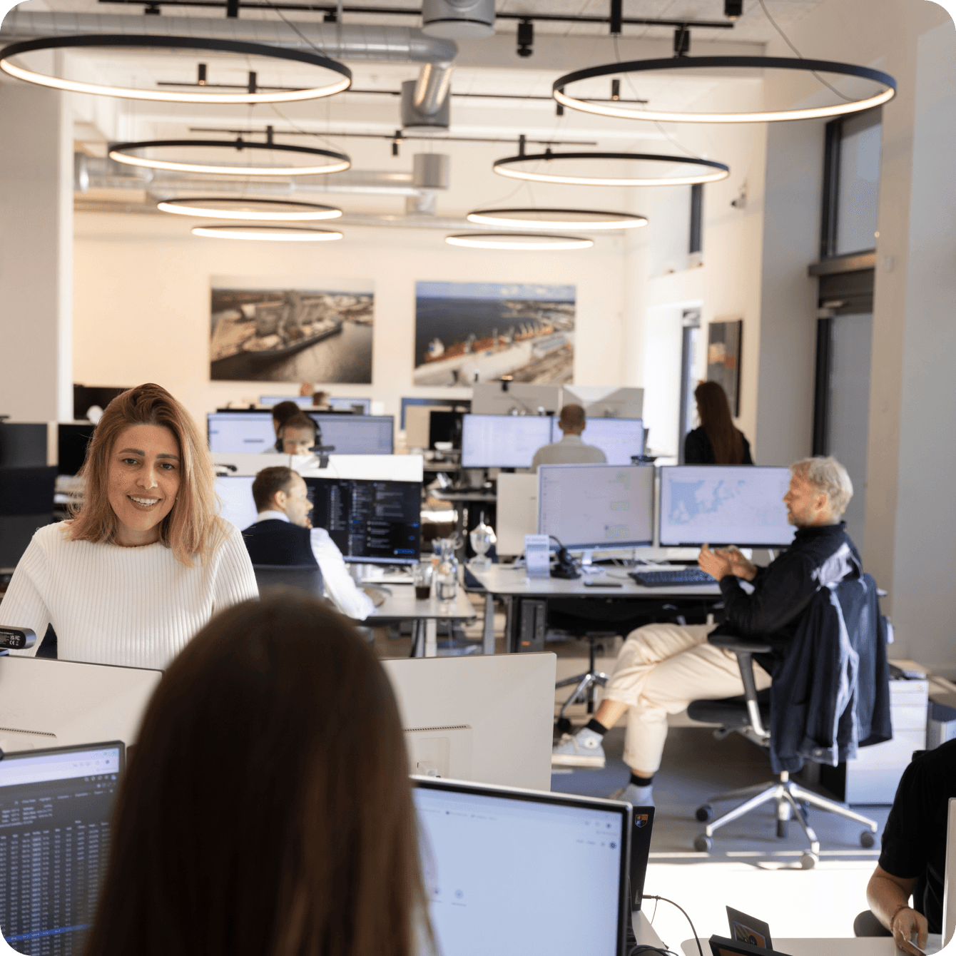 CM Navigator team members working at desks in a bright modern open-plan office, representing the people and culture behind the commodity market intelligence platform built on the Copenhagen Merchants Group network